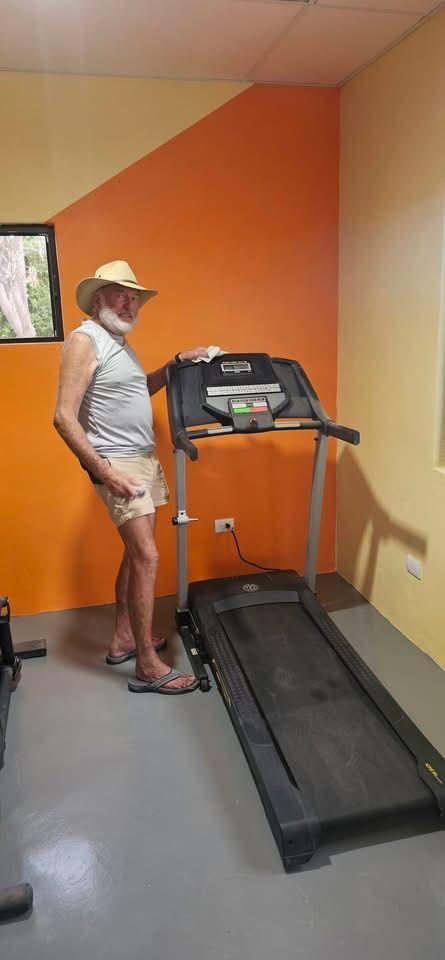 Resident standing at the treadmill in the community gym